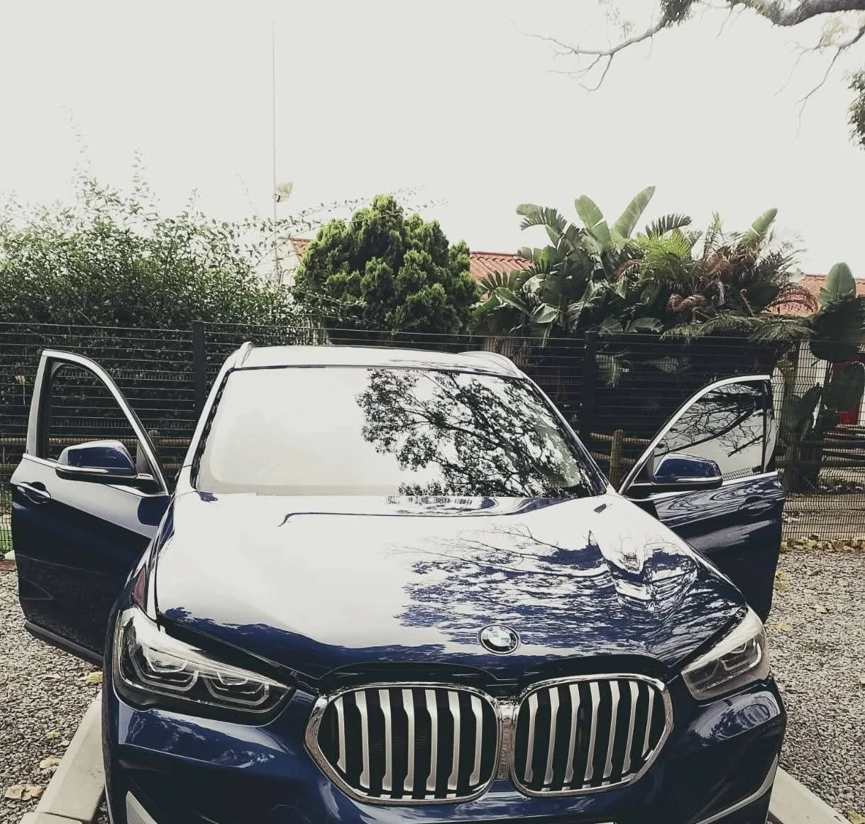Dark BMW with its front windscreen visible at a glass service job